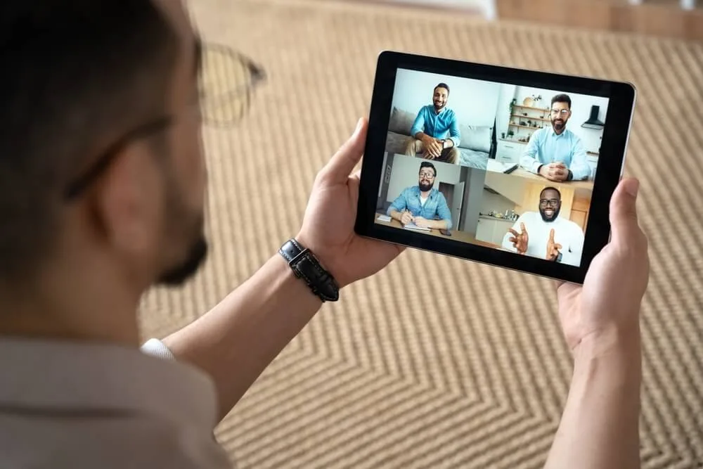 An advisor discusses M&A legacy planning with a virtual team on a tablet.