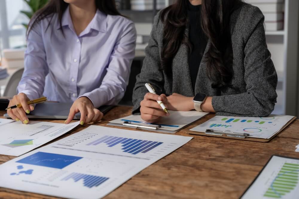A business preparation team looks at reports on paper.